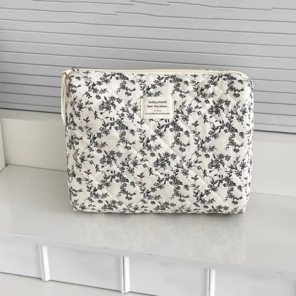 Trousse de toilette matelassée ouverte remplie de produits cosmétiques variés démontrant son volume généreux