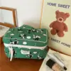 Femme utilisant sa trousse de toilette en coton motif animaux lors d'un voyage