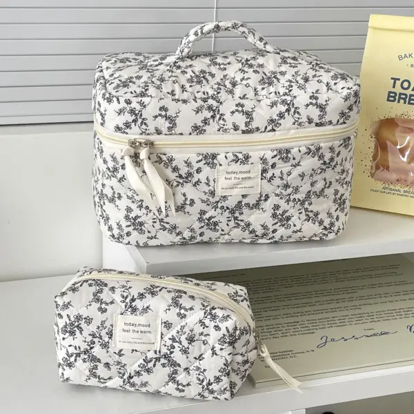 Trousse de toilette matelassée noire posée sur un plan de travail avec produits cosmétiques, démontrant sa praticité