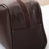Trousse masculine posée sur valise cabine pour déplacement professionnel