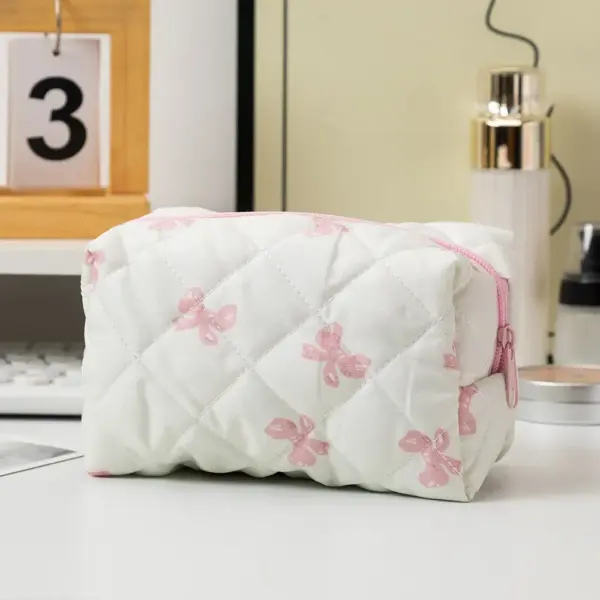 Trousse de toilette fleurie posée sur un meuble de salle de bain avec produits beauté