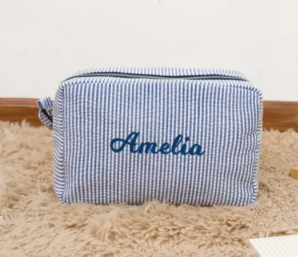 Gros plan sur la broderie personnalisée d'un prénom sur trousse en coton