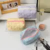 Zoom sur le nœud en tissu fleuri fixé sur la trousse de toilette rectangulaire
