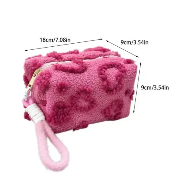 Trousse de toilette rose peluche glissée dans un bagage cabine pour illustrer sa praticité