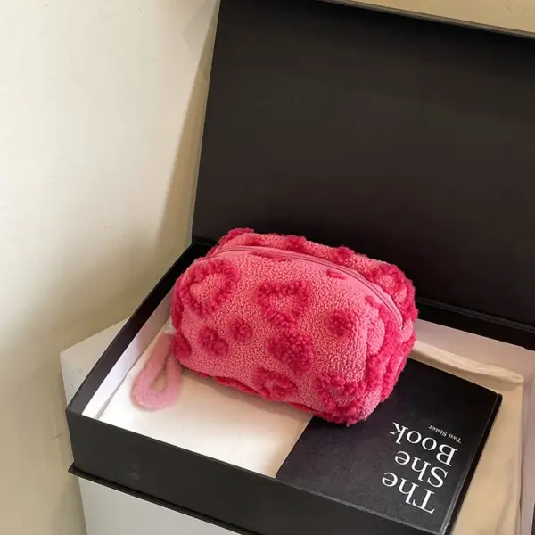 Femme tenant la trousse rose par la poignée pour montrer sa taille et son élégance