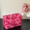 Gros plan sur la matière peluche moelleuse et le motif cœur décoratif de la trousse